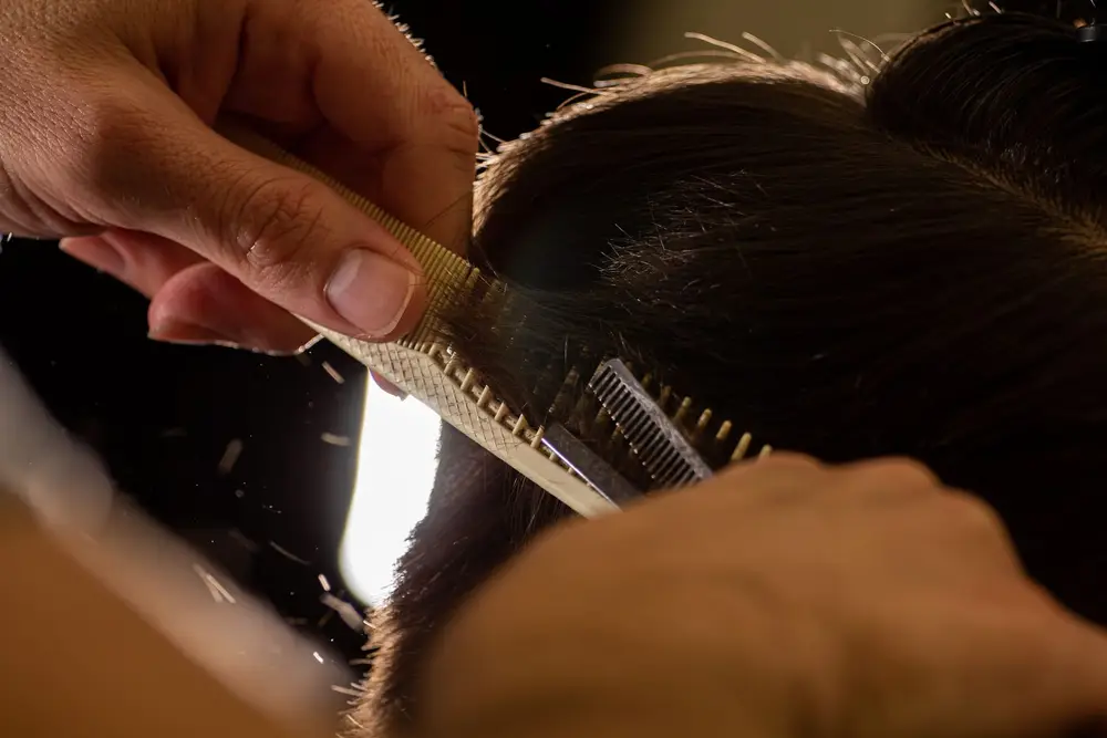 Barbeiro finalizando corte com degradê e barba alinhada na Barbearia Sparta